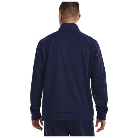 A person is standing with their back facing the viewer wearing a navy blue jacket with a collar in a plain white background. Their hands rest at their sides.