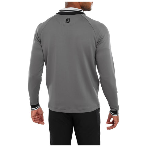 A person wearing a gray long-sleeve shirt with a black and white collar is facing away, showing a logo on the back, with their left hand raised slightly in a relaxed position.