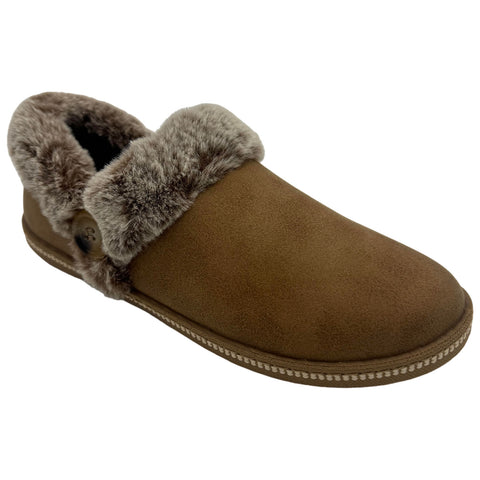 A brown slipper with a soft fur lining and a cuff is positioned to emphasize its comfortable design. The background is a neutral white surface.