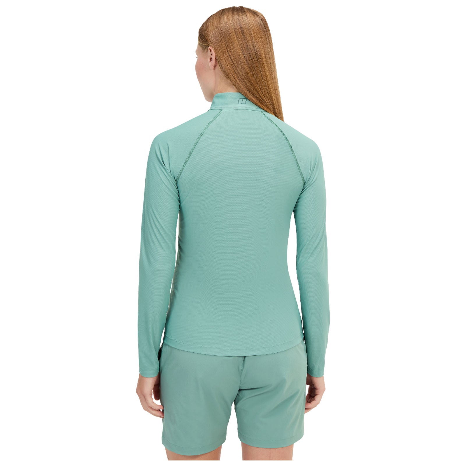 A blue long-sleeved athletic shirt is displayed on a model who poses with a slight head turn. The background is plain, focusing attention on the shirt design and fit.