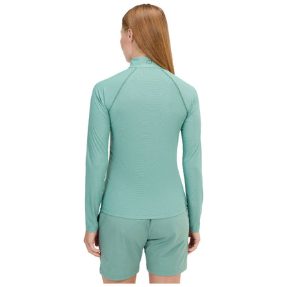 A blue long-sleeved athletic shirt is displayed on a model who poses with a slight head turn. The background is plain, focusing attention on the shirt design and fit.