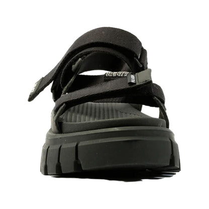 A black sandal features adjustable straps and a textured footbed while positioned upright against a plain background suggesting a casual footwear option for comfort and style.