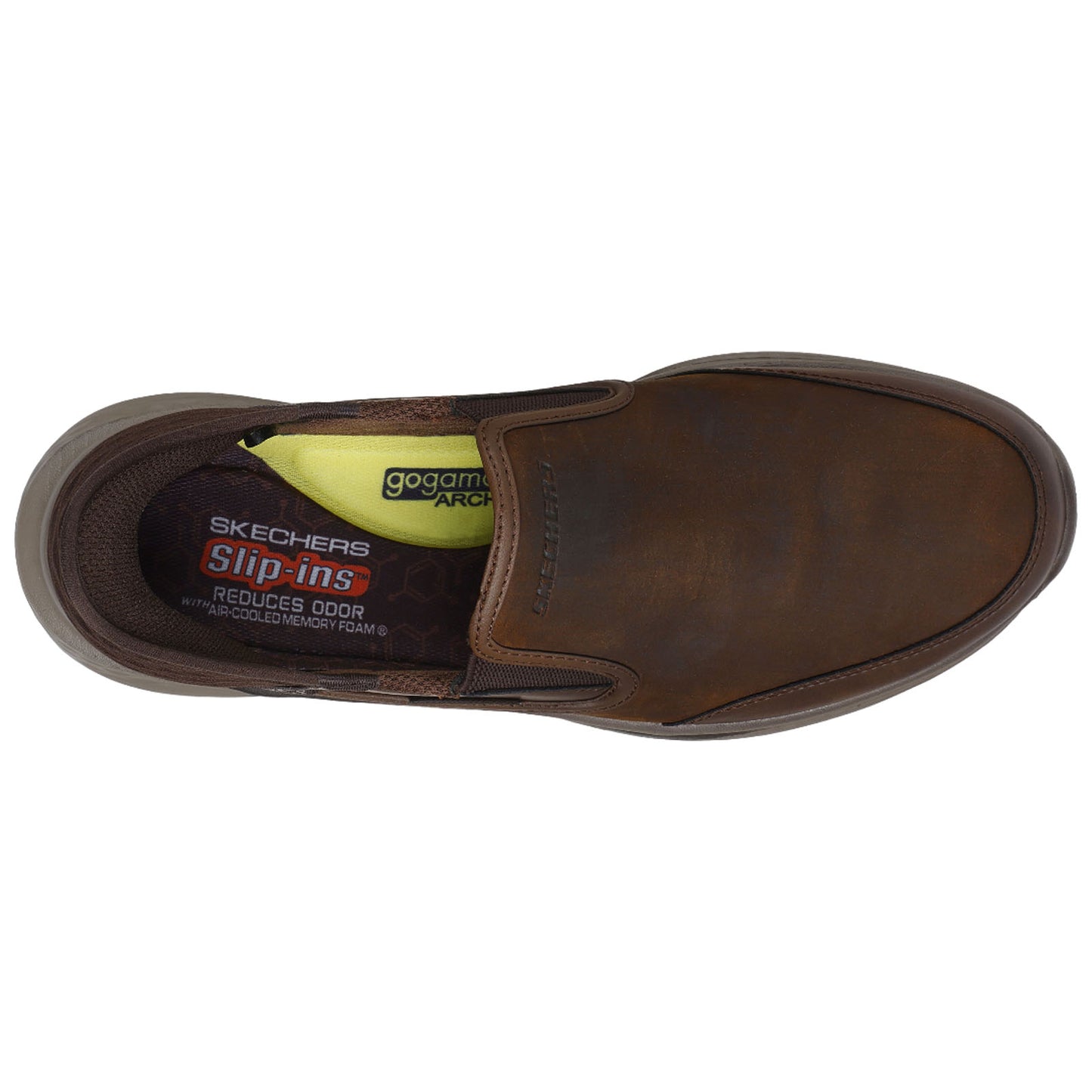 A brown slip-on shoe rests upright revealing its inner sole with text on the lining showcasing Skechers brand and features such as reduced odor and air-cooled memory foam.
