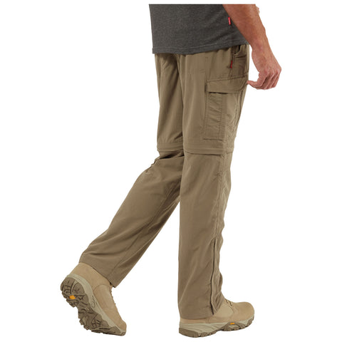 A person is walking in light-colored cargo pants and beige hiking shoes showcasing functionality and comfort in a casual outdoor setting, highlighting practicality for movement and exploration.