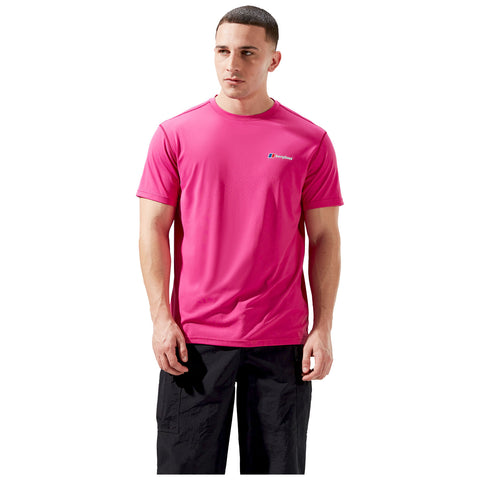 A man stands wearing a bright pink athletic shirt and black pants with a relaxed expression in a neutral background, suggesting a focus on outdoor or fitness activity.