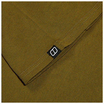 A folded piece of olive green fabric shows a black label with a white logo in the corner while the surrounding texture is smooth and consistent throughout.