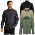 A man wearing a gray long-sleeve shirt stands with his left hand in his pocket while three different colored shirts in black green and beige are displayed beside him.