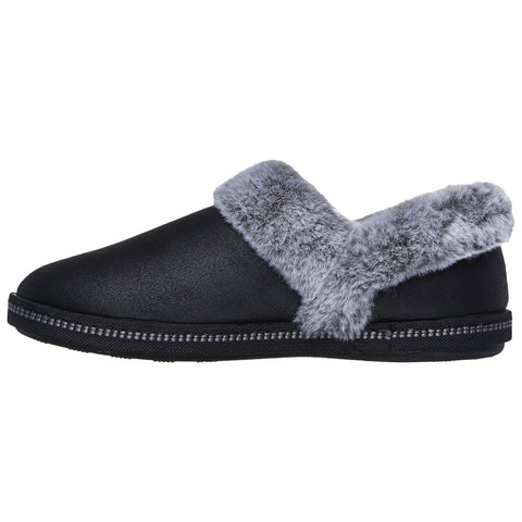 A black slipper with a gray fuzzy collar rests on a flat surface showcasing its simple and cozy design ideal for indoor wear.