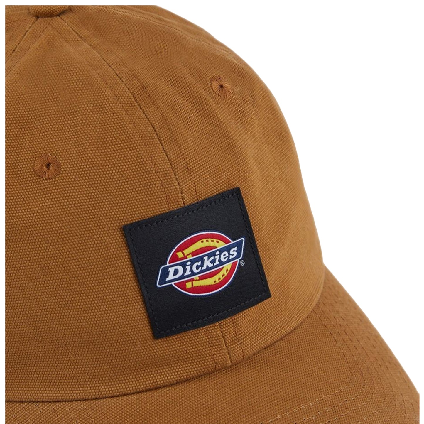 A tan cap with a textured fabric features a black rectangular patch displaying the "Dickies" logo in colorful lettering, placed against a neutral background.