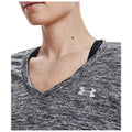 A close-up view of a person’s neckline wearing a grayish-black athletic shirt featuring a v-neck design with a visible logo on the fabric and a black inner layer underneath.