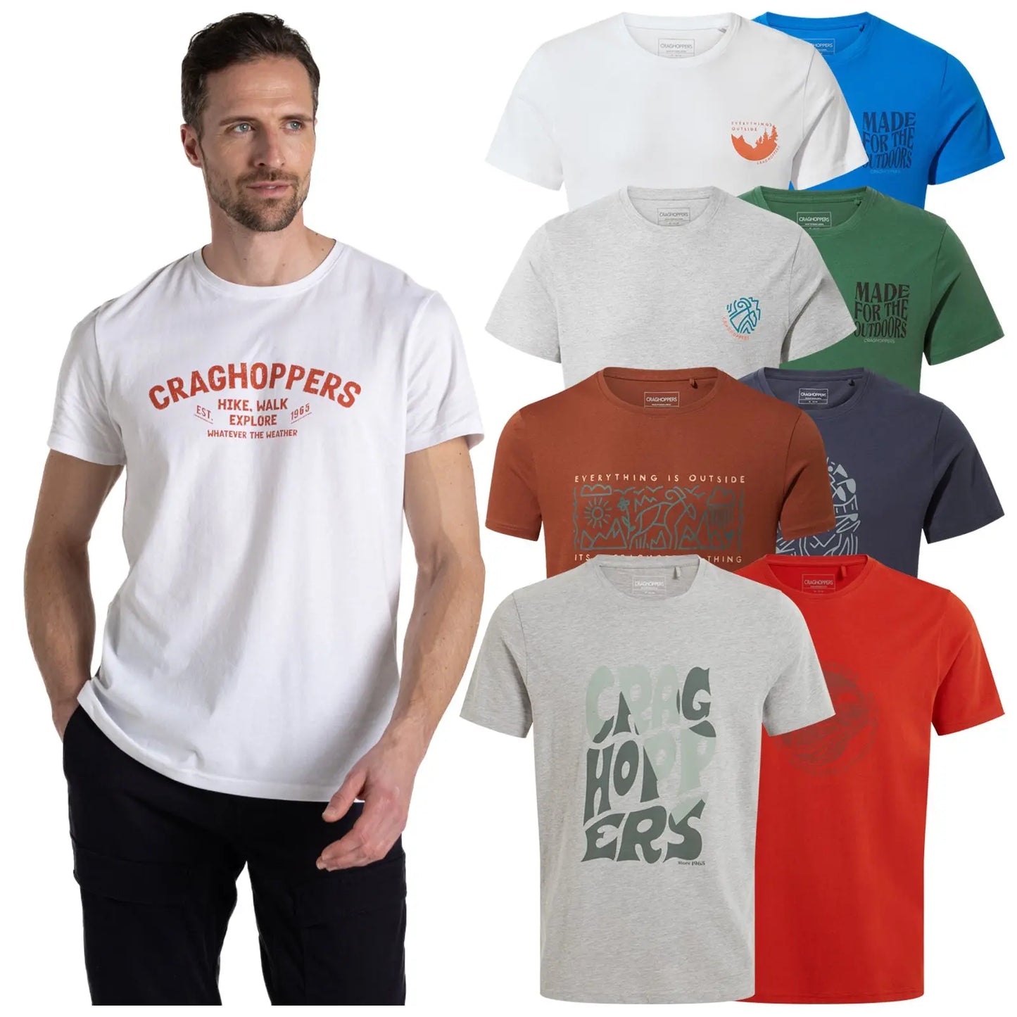 A man stands wearing a navy t-shirt with a graphic design while several other colorful t-shirts are displayed beside him in varying styles and colors against a neutral background.