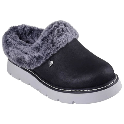 A black slip-on shoe with a fuzzy gray collar rests on a white surface showcasing its comfortable design and soft lining ideal for casual wear in relaxed environments.