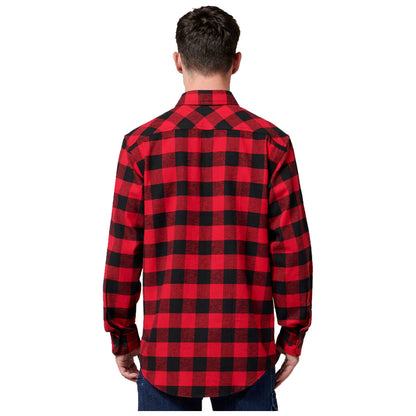 A person is standing with their back facing the viewer wearing a red and black checkered flannel shirt with long sleeves and blue jeans in a simple white background.