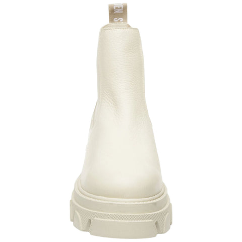 A cream-colored ankle boot is centered with a textured surface and a sturdy sole featuring a pronounced tread design facing backward in a neutral setting.