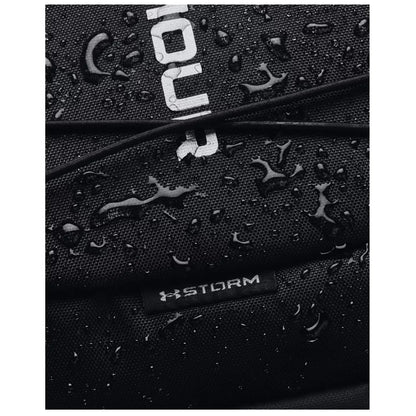 A black fabric bag is covered in water droplets showcasing its waterproof surface with a visible logo and the word STORM on a tag, indicating durability in wet conditions.