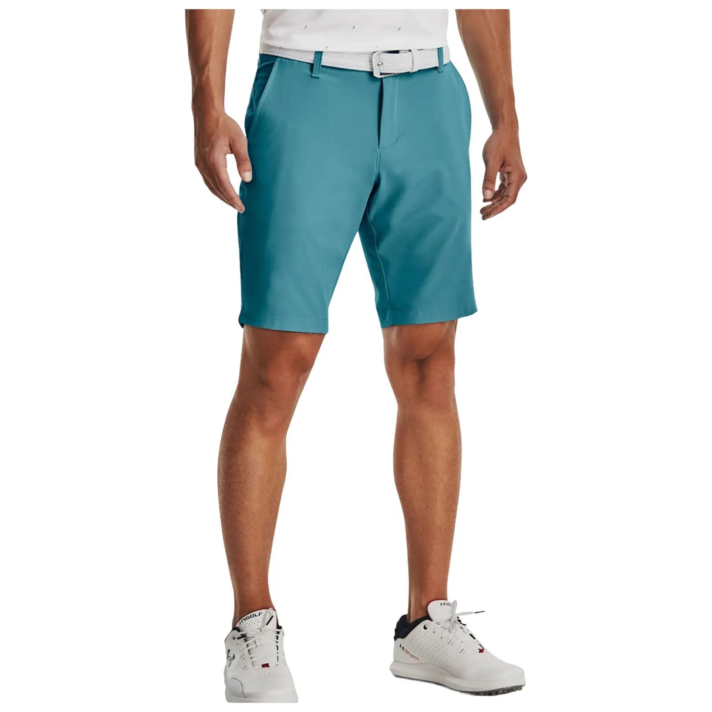 A pair of teal golf shorts is being worn by a man standing upright. He is wearing a white shirt and white athletic shoes. The background is plain white.