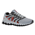 A gray and red athletic shoe rests on a flat surface featuring a mesh upper and a cushioned sole showcasing its lightweight design ideal for running or casual wear.