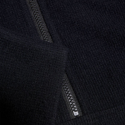 Black fabric with a textured surface features a visible zipper partially open at the edge suggesting an outerwear garment in a neutral background that highlights the material's softness and detail.