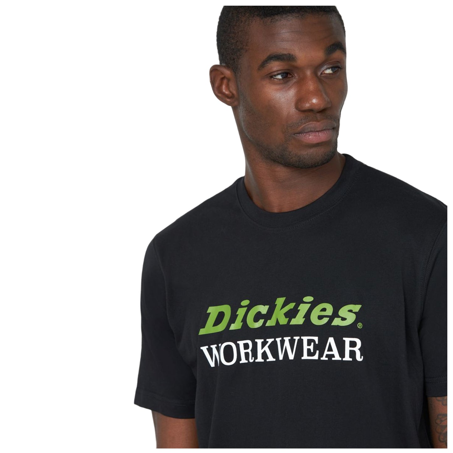 A man wears a black t-shirt displaying the text "Dickies" in green and "WORKWEAR" in white while looking to his left in a neutral setting.