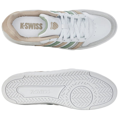 A pair of K-Swiss sneakers rests horizontally showing the white upper with beige and green accents the shoe's sole features a textured grip pattern suitable for various surfaces.