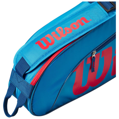 A blue sports bag with a prominent red "Wilson" logo on the side features a red zipper and a strap for carrying, positioned against a plain white background.