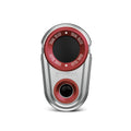 A compact electronic device with a metallic silver body features a circular red dial labeled "DUAL OLED" and a small black lens at the bottom center for audiovisual functionality.