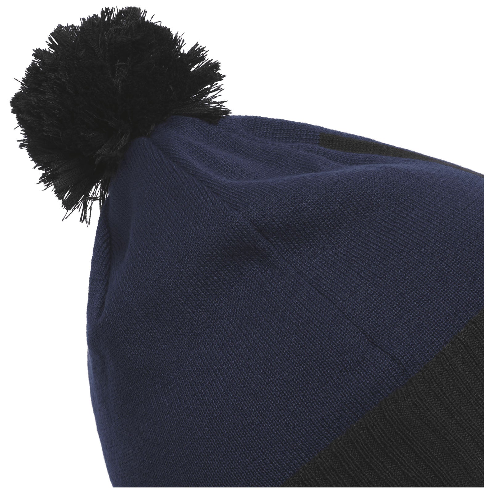 A dark blue knitted beanie with a black pom-pom on top is shown angled, emphasizing its texture and color against a white background.