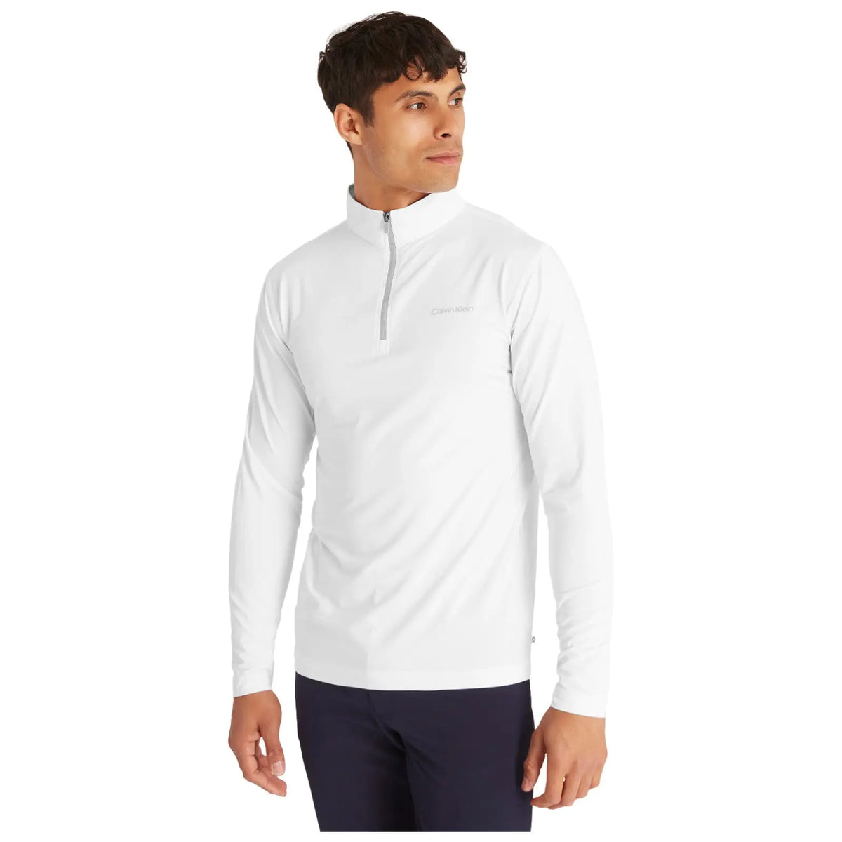 A man is wearing a white zip-up long-sleeve shirt while looking to his left in a neutral background highlighting the shirt's clean design with a subtle logo.