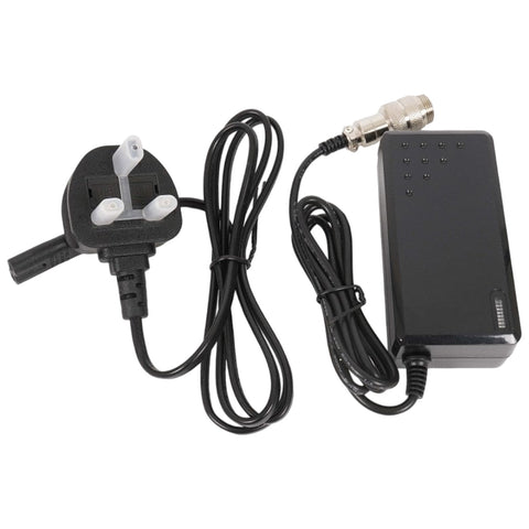 A black power adapter with an attached UK plug and two cables extends from it one leading to a device and the other connected to an output socket