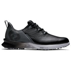 A black athletic shoe with a textured surface and a gray outsole sits on a flat surface showcasing its sleek design and lacing system meant for comfort and performance.