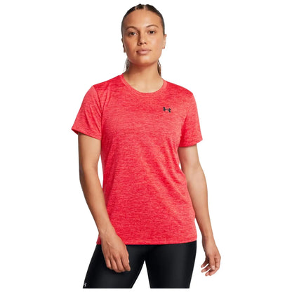 A woman stands confidently wearing a bright red athletic t-shirt with short sleeves and black workout leggings in a neutral background, appearing ready for physical activity or exercise.