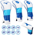 Three golf club headcovers in blue and white are arranged together with a fourth smaller headcover nearby. Below them are circular tags labeled with numbers from two to seven.