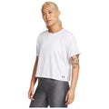 A person stands confidently wearing a white t-shirt and gray leggings showcasing visible tattoos on their arms with a neutral background emphasizing their casual athletic attire.