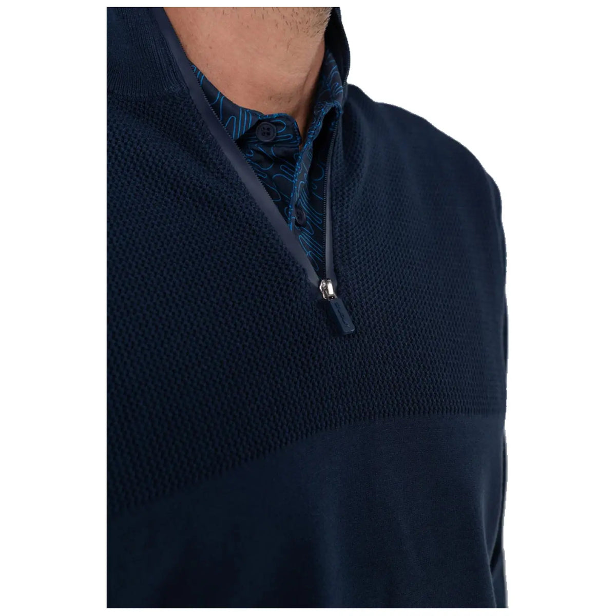 A navy pullover with a half-zip design features a textured upper section and a patterned collar underneath. The focus is on the garment, highlighting its stylish and casual design.