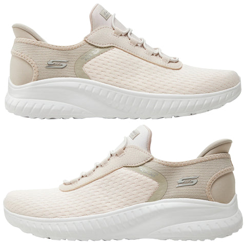 Light beige athletic shoes are positioned vertically with one shoe on top of the other showcasing their breathable mesh design and cushioned soles set against a plain white background.