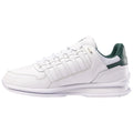 A white athletic shoe with green accents rests on a flat surface showcasing a sleek design featuring mesh and leather material with lace-up closure and a cushioned sole.