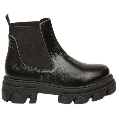 A black chelsea boot made of textured leather features elastic sides and a thick lug sole suitable for rugged terrain set against a plain background highlighting its design and materials.