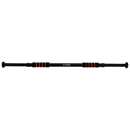 A black and red pull-up bar is extended horizontally with rubber grips for hands it is designed for home workouts typically situated in a doorway or open space.