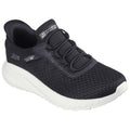 A black athletic shoe with a textured upper and white sole sits in a neutral setting showcasing its slip-on design and flexible construction aimed at comfort and ease of wear.