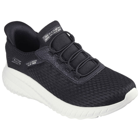 A black athletic shoe with a textured upper and white sole sits in a neutral setting showcasing its slip-on design and flexible construction aimed at comfort and ease of wear.