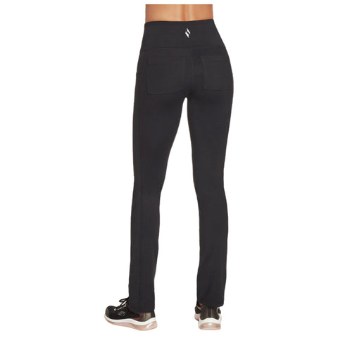 Black athletic leggings are being worn by a person who is standing with their back facing the viewer, revealing a high waistband and pockets, paired with black athletic shoes.