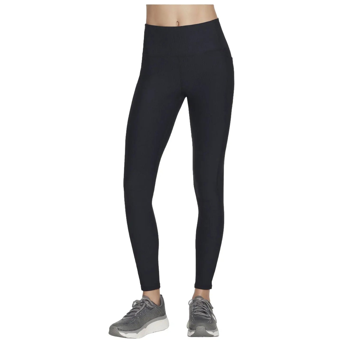 A pair of black leggings are displayed standing upright showcasing a ribbed texture with a high waistband alongside gray athletic shoes suggesting an active lifestyle.