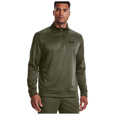 A man wears a green athletic pullover with a zipper and a logo on the chest while standing straight and looking directly at the viewer in a neutral background.