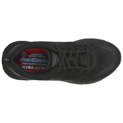 A black athletic shoe rests flat displaying a textured surface and laces tied, with visible branded labels inside indicating features like slip resistance and memory foam cushioning in a neutral environment.