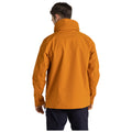 A person wearing an orange jacket stands with their back facing the viewer in a plain white background, suggesting a focus on the jacket's color and design without any distractions.