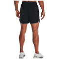 A man stands facing away wearing black athletic shorts and white sneakers his muscular legs are visible in a neutral background showcasing his athletic build and readiness for activity