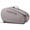 A gray tennis bag is positioned on a flat surface featuring a zipper and a handle its side displays the word Wilson in bold white letters designed for carrying tennis equipment.