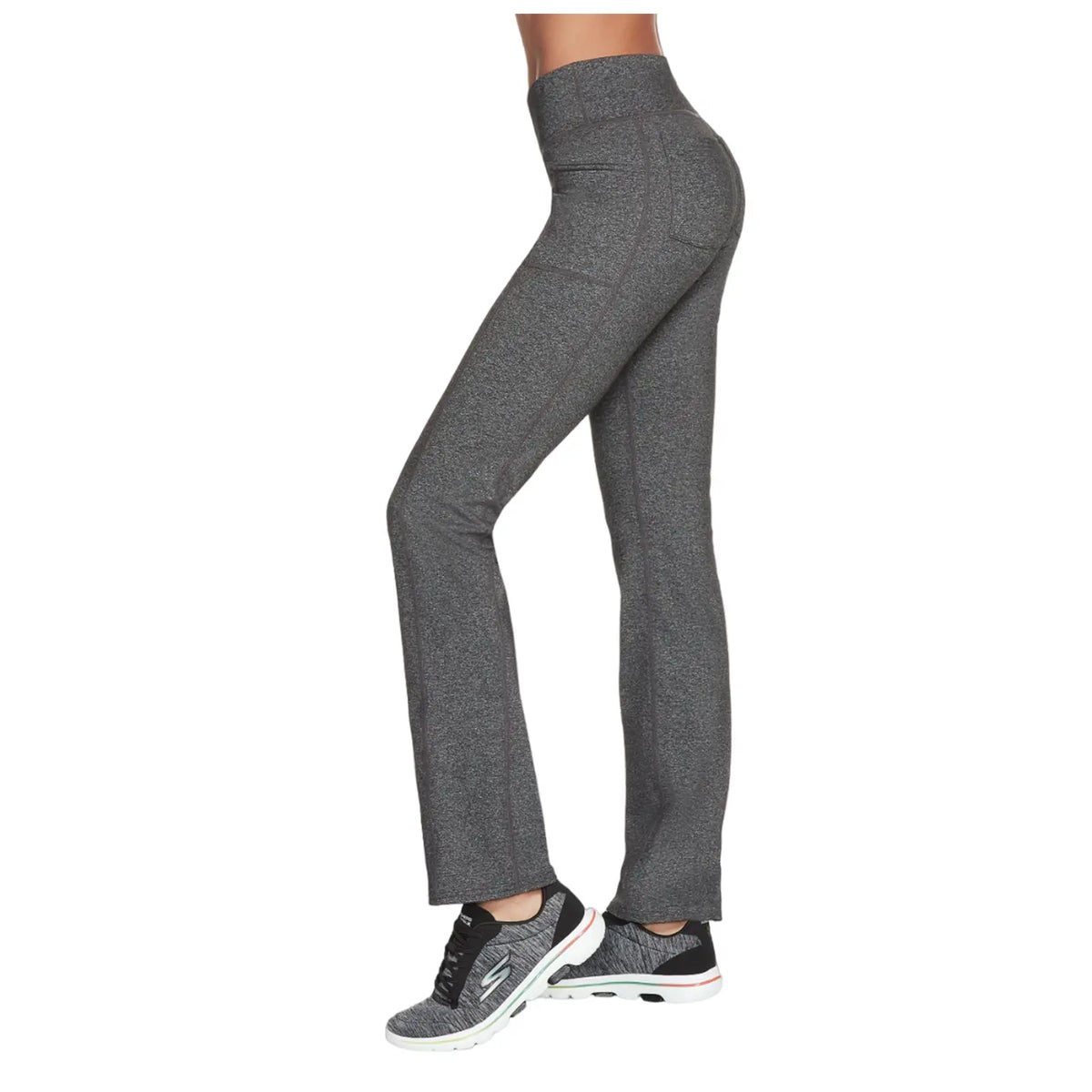 Gray athletic pants are worn by a person standing sideways wearing black sneakers in a neutral background showcasing a fit silhouette designed for comfort and performance.