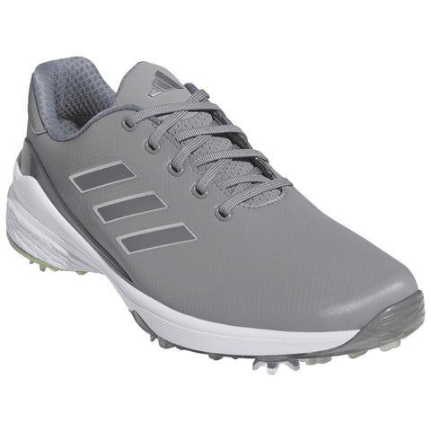 A gray golf shoe with a textured upper is positioned prominently featuring lace detailing and three stripes on the side set against a plain white background.