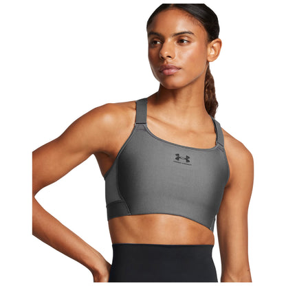 A woman wears a gray athletic sports bra with thick straps while looking to the side. The context suggests an activewear focus, emphasizing comfort and style for physical activities.